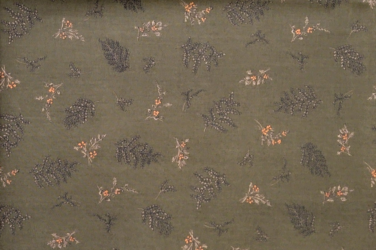 Olive green fabric with a repeating pattern of small brown leaves and peach-orange flowers