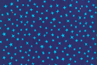 A close-up of a fabric pattern featuring small, bright blue stars scattered across a dark navy blue background.