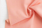 Close-up of pink fabric with 'Fableism' branding.