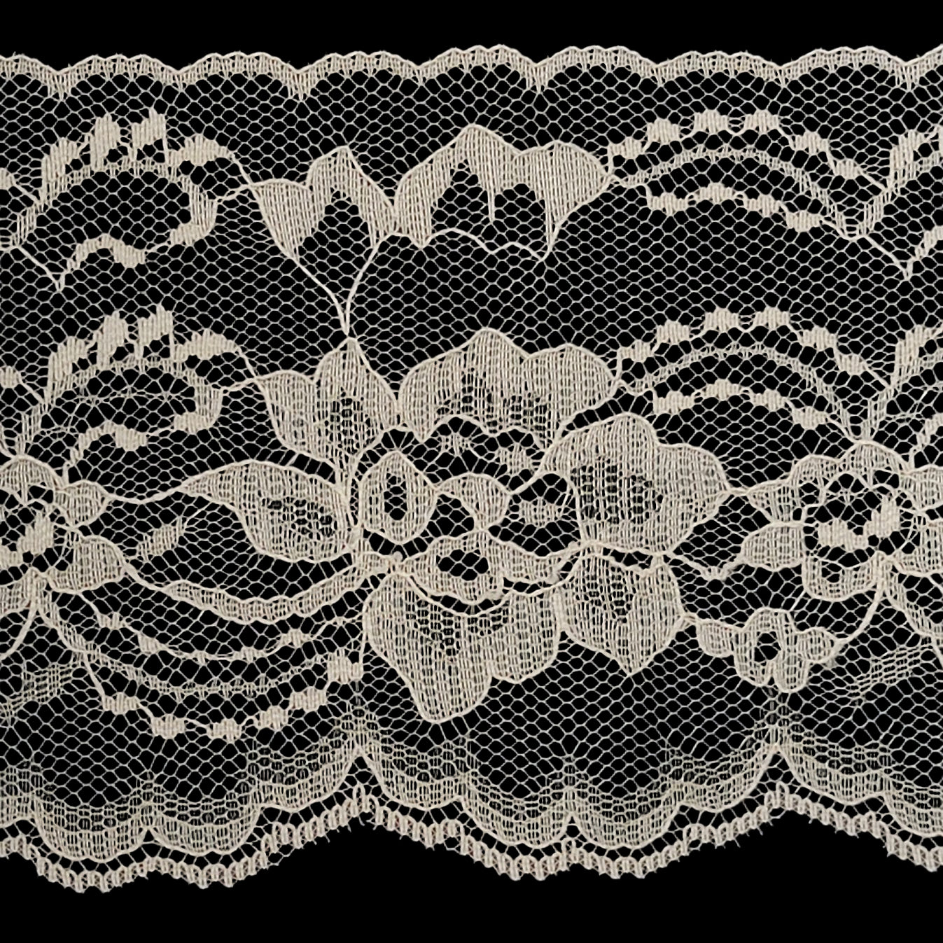 Close-up of lace fabric with floral pattern on a dark background
