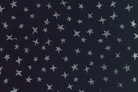 Dark navy blue fabric with a repeating pattern of small silver glitter stars.