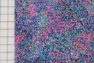 Multicolored speckled fabric on a grid background