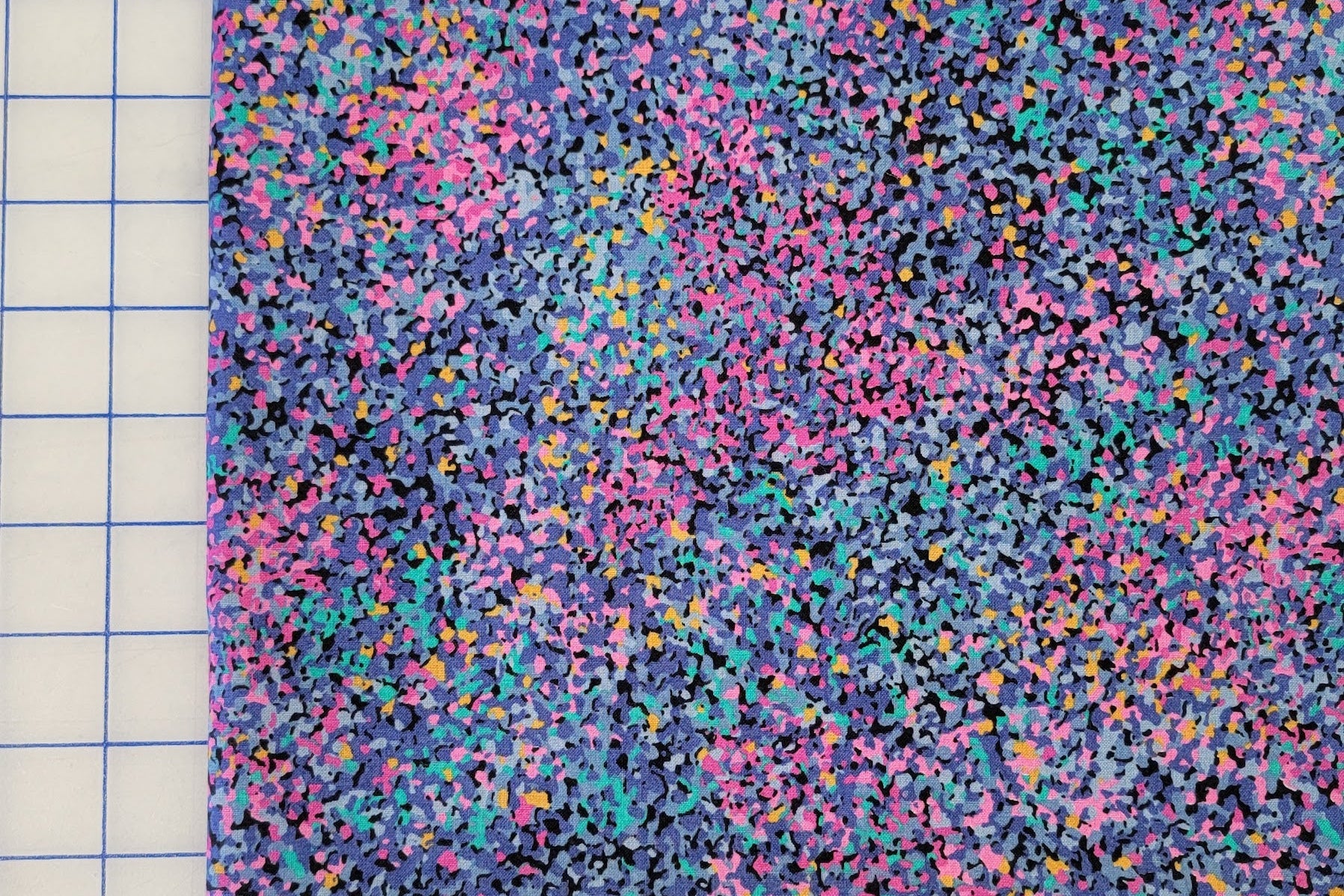 Multicolored speckled fabric on a grid background